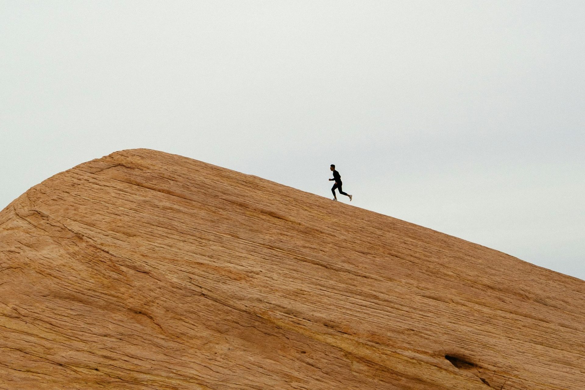 person running on top on hill during daytime